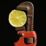 a lime slice is being held in a wrench