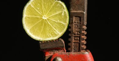 a lime slice is being held in a wrench